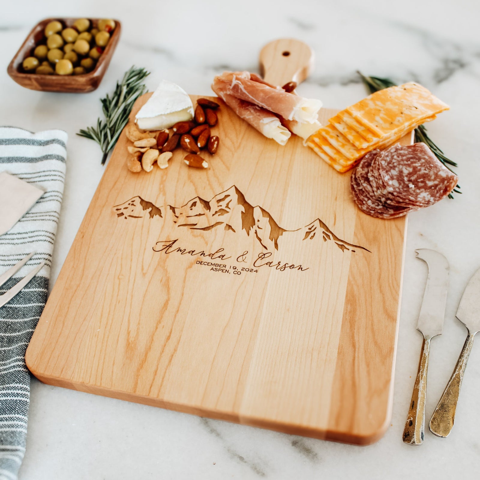 Cutting board with personalized mountain scene engraved as gift.