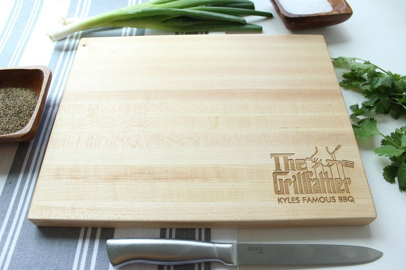 Sugar Tree Gallery light wood cutting board with "The Grillfather" and "Kyles Famous BBQ" engraved. Features butcher block construction.